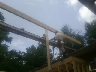 Carpenter setting a ridge beam over a new addition frame — Ice Dam Removal by Roofing Brothers in East Elmhurst