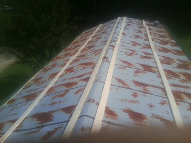 Rusted metal roof panels with new wood purlins before replacement — Storm Damage Roof Repair in East Elmhurst by Roofing Brothers