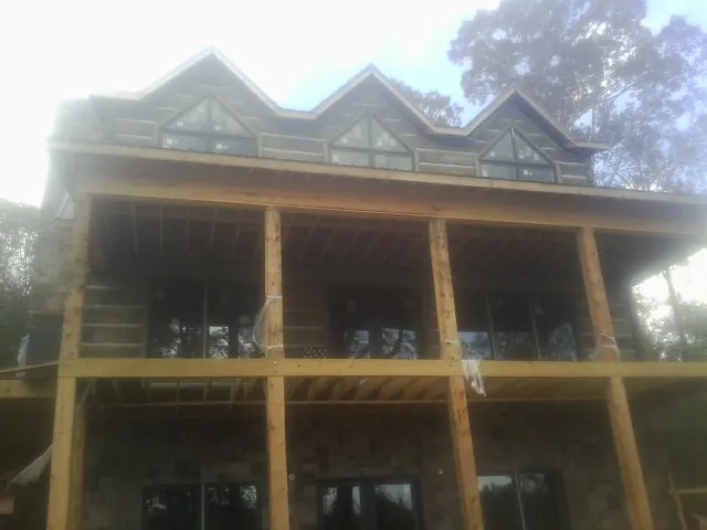 Dormers and porch framing on a large log home under construction — Roof Coating work by our crew in East Elmhurst