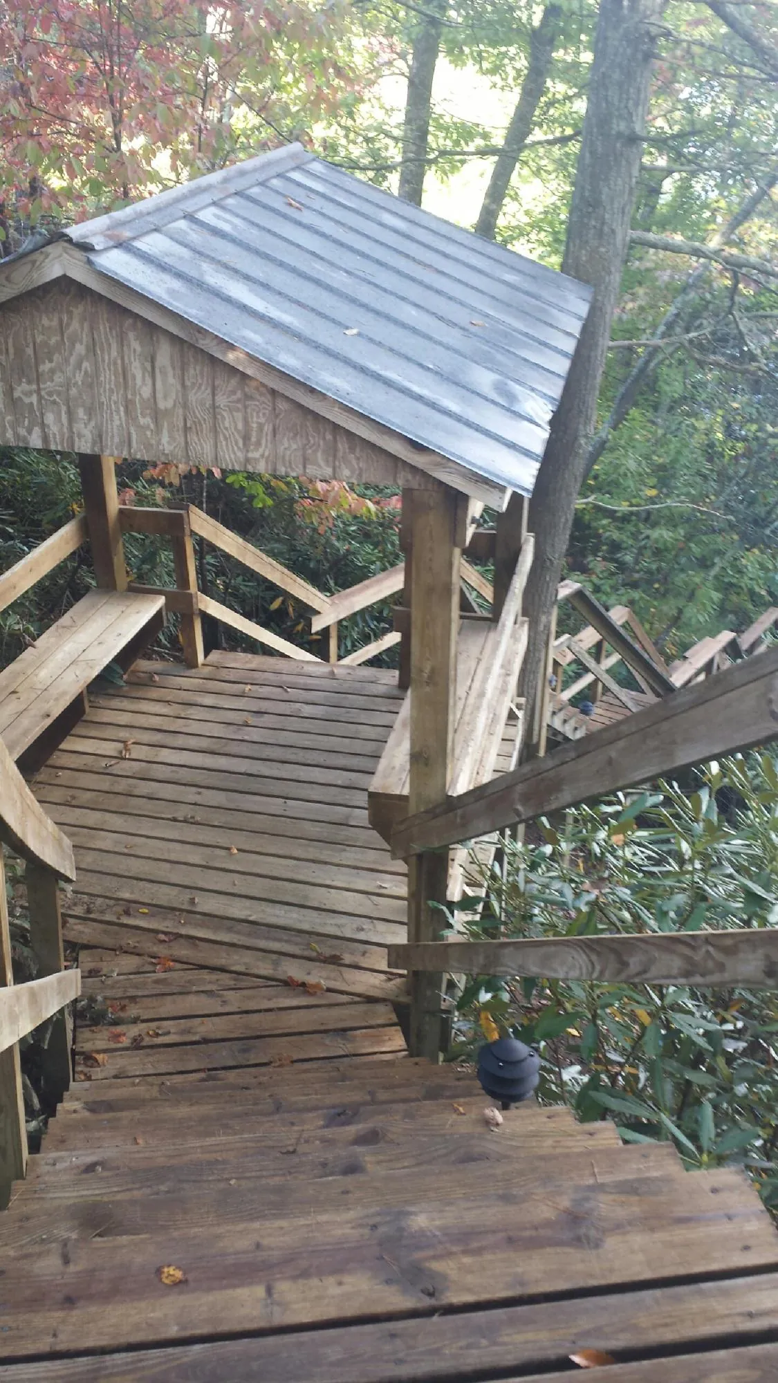 Metal roofed shelter over wooden steps on a wooded walkway — Skylight Repair & Installation work by our crew in East Elmhurst