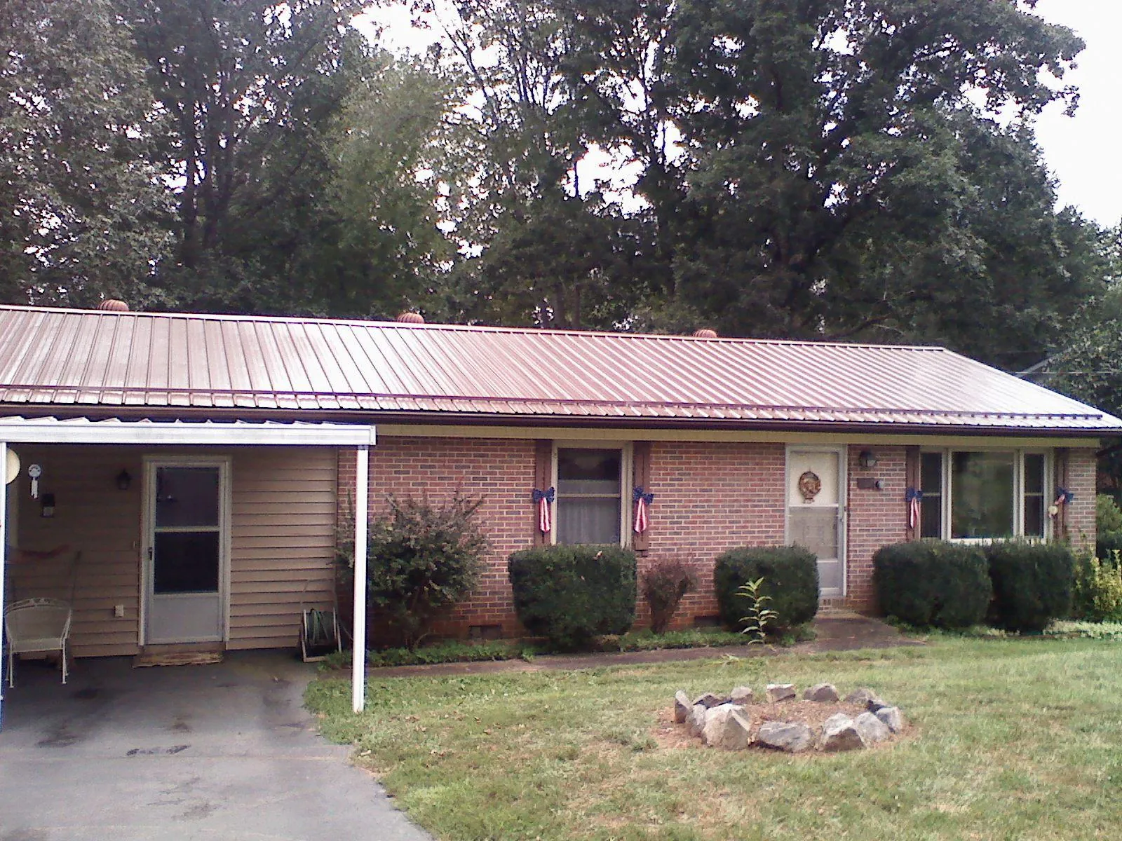 Bronze metal roof and carport on a brick ranch home — Roof Repair work by our crew in East Elmhurst